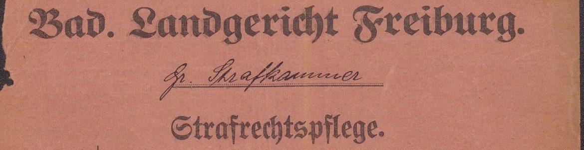 Abgedruckt ist der Schriftzug „Badisches Landegericht Freiburg“ in Fraktur-Schrift. Darunter ist auf einer Ausfülllinie in lateinischer Schreibschrift „Große Strafkammer“ geschrieben und wiederum darunter abermals in Fraktur „Strafrechtspflege“.